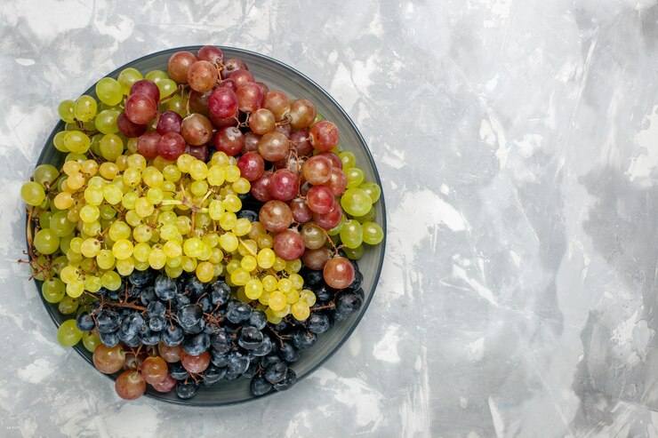 Foto gratuito vista superiore dell'uva fresca frutta succosa e pastosa all'interno della piastra sullo sfondo bianco frutta mellow succo di vino fresco