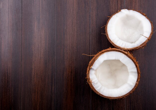 Vista superiore della noce di cocco fresca a metà marrone su una superficie di legno