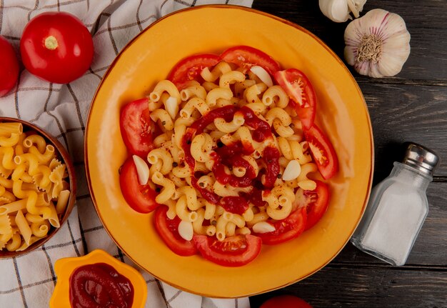 Vista superiore della pasta di maccheroni in zolla con i pomodori