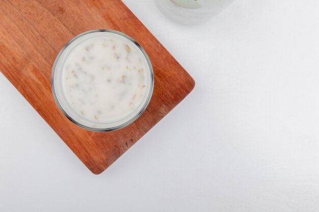 Vista superiore della zuppa di yogurt azero in vetro sul tagliere e sfondo bianco con spazio di copia