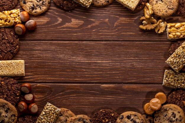 Vista superiore delle noci e dei biscotti con lo spazio della copia su un di legno