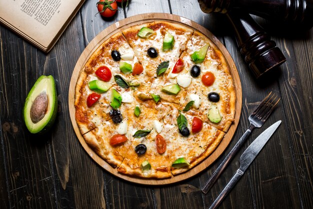 Vista superiore delle olive delle spezie del basilico del pomodoro del formaggio della pizza dell'avocado