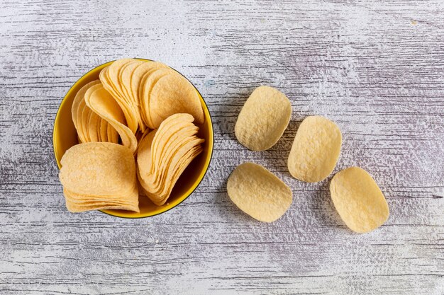 Vista superiore delle patatine fritte in ciotola sull'orizzontale bianco