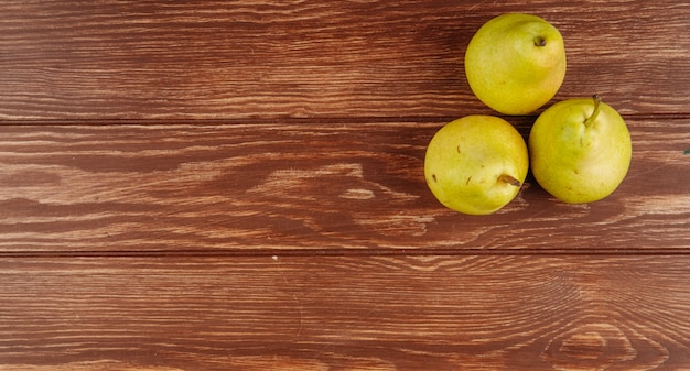 Vista superiore delle pere mature fresche su fondo di legno con lo spazio della copia