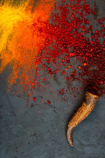 Vista superiore delle spezie rosse della polvere di sumac e del peperoncino rosso con curry sul nero