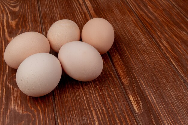 Vista superiore delle uova fresche del pollo isolate su un fondo di legno