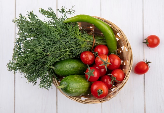 Vista superiore delle verdure come merce nel carrello del cetriolo dell'aneto di pomodoro su superficie di legno