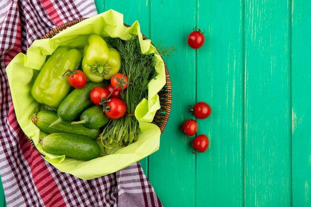 Vista superiore delle verdure come merce nel carrello dell'aneto del cetriolo del pomodoro del pepe sul panno del plaid e sulla superficie di verde