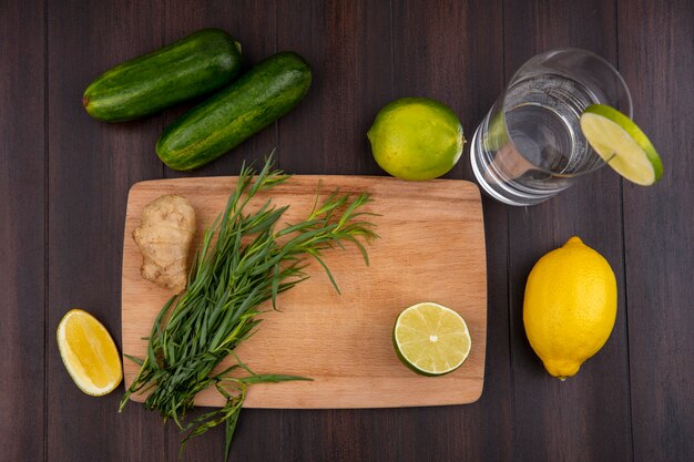 Vista superiore di dragoncello su una tavola di cucina in legno con cetriolo limoni su superficie di legno