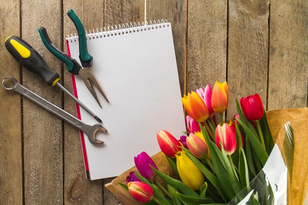 Vista superiore di strumenti, notebook e fiori per la giornata del padre