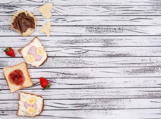 Vista superiore di toast con marmellata, yogurt e copia spazio su sfondo bianco in legno orizzontale