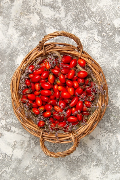 Vista superiore fresca acida cornioli all'interno del cestello sulla superficie bianca bacca di frutta vitamina acido dolce pianta selvatica albero