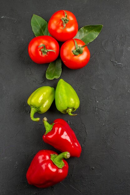 Vista superiore verdure fresche pomodori e peperoni sul tavolo scuro, insalata di colore pasto maturo