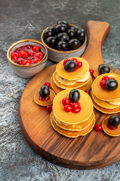 Vista verticale dei classici pancake americani serviti con frutta sul tagliere