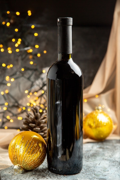 Vista verticale della bottiglia di vino in vetro rosso per feste in famiglia e accessori decorativi