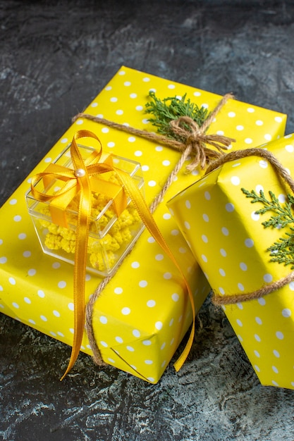 Vista verticale dello sfondo di Natale con bellissime scatole regalo gialle sul tavolo scuro
