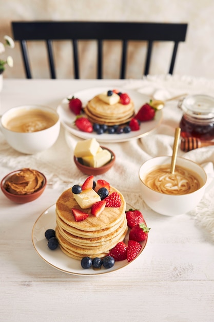 Vista verticale di frittelle vegane e frutta colorata a colazione