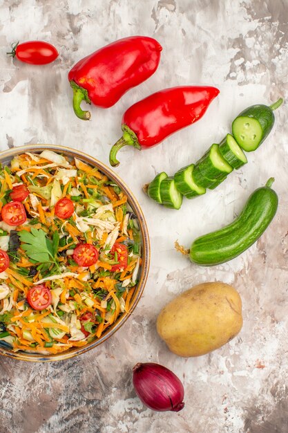 Vista verticale di gustosa insalata vegana e verdure intere e tritate