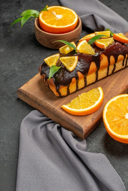 Vista verticale di morbide gustose torte tagliate limoni con biscotti sul tagliere di legno