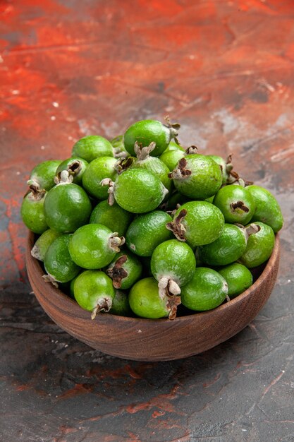 Vista verticale di piccoli feijoas freschi di bomba vitaminica verde in un vaso marrone