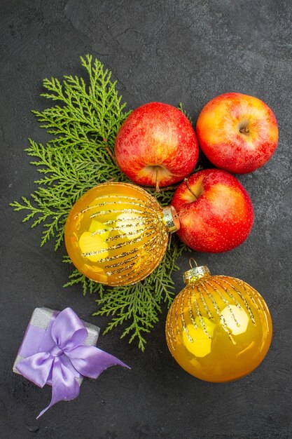 Vista verticale di regali e mele fresche biologiche naturali e accessori decorativi su sfondo nero