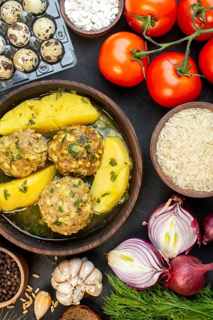 Vista verticale di un delizioso pasto di polpette di verdure fresche picchi fette di pane uova verdi su sfondo nero