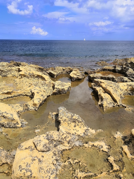 Vista verticale di una bellissima spiaggia con rocce a Malta catturata in una giornata di sole
