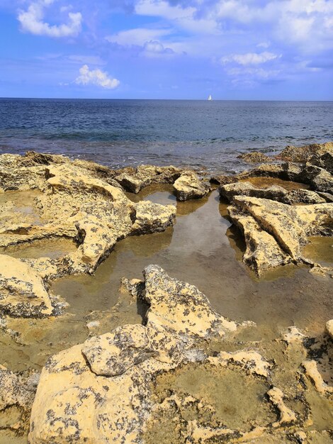 Vista verticale di una bellissima spiaggia con rocce a Malta catturata in una giornata di sole