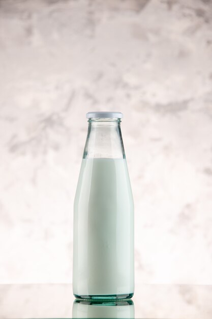 Vista verticale di una bottiglia di vetro di latte chiusa e riempita su sfondo di fumo bianco con spazio libero