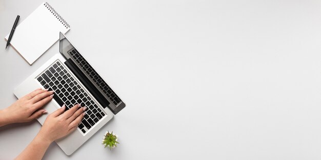 Visualizzazione superiore della persona che scrive sul portatile con spazio di copia