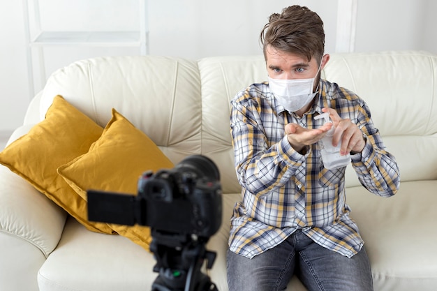 Vlogger che registra video a casa con disinfettante per le mani