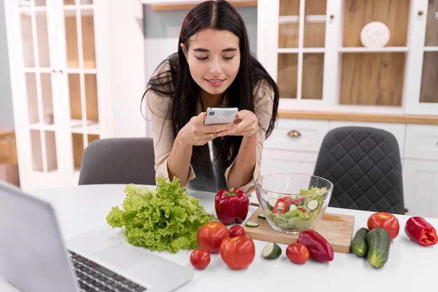 Vlogger femminile che scatta foto con lo smartphone