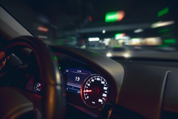 Volante dell'auto e vista della strada notturna dal primo piano dell'auto