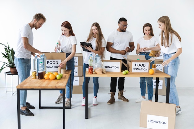 Volontari che preparano scatole con disposizioni per la donazione