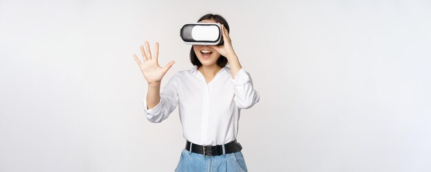 Vr chat Ragazza asiatica che dice ciao in occhiali per realtà virtuale sorridente concetto entusiasta di comunicazione e tecnologia futura sfondo bianco