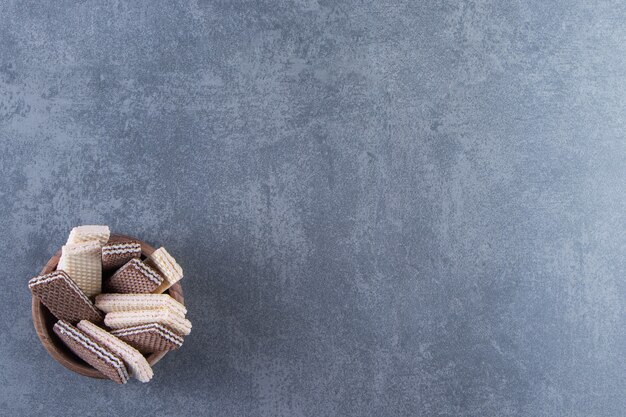 Wafer al latte e cioccolato in una ciotola, sullo sfondo di marmo.