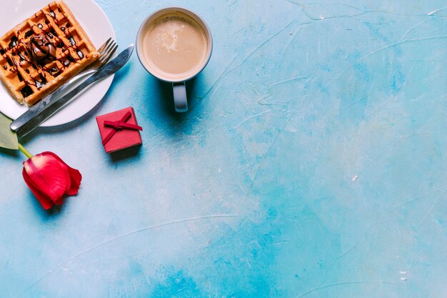 Waffle belga con tulipano rosso sul tavolo