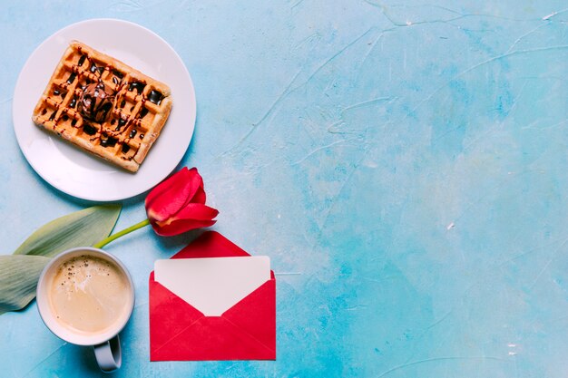 Waffle belga sul piatto con tulipano rosso