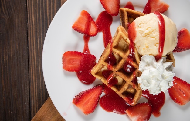 Waffle con fragole, gelato alla vaniglia e panna montata