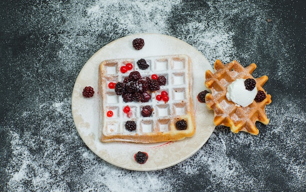 Waffle delizioso vista dall'alto nel piatto con more, forcella su oscurità. orizzontale