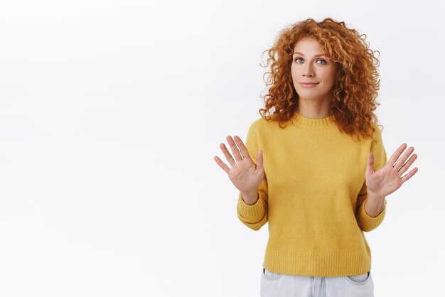 Wow, tieni uno calmati Rilassata donna riccia rossa carina prova ad abbassare la tensione alza le braccia per fermare il suo gesto ok sorridendo dicendo che tutto va bene convincere qualcuno che è abbastanza