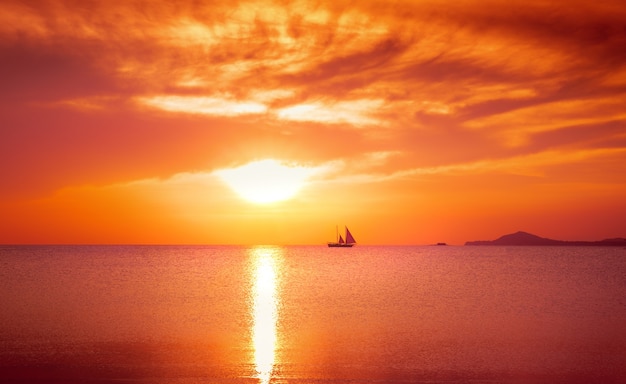 Yacht a vela contro il tramonto. Paesaggio di lifestyle di vacanza con skyline. Processo dell&#39;annata.