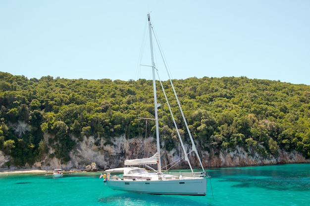 Yacht bianco che naviga nella laguna turchese in una giornata di sole