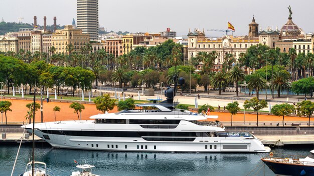 Yacht ormeggiati nel porto del Mar Mediterraneo, edifici, strada, verde a Barcellona, Spagna