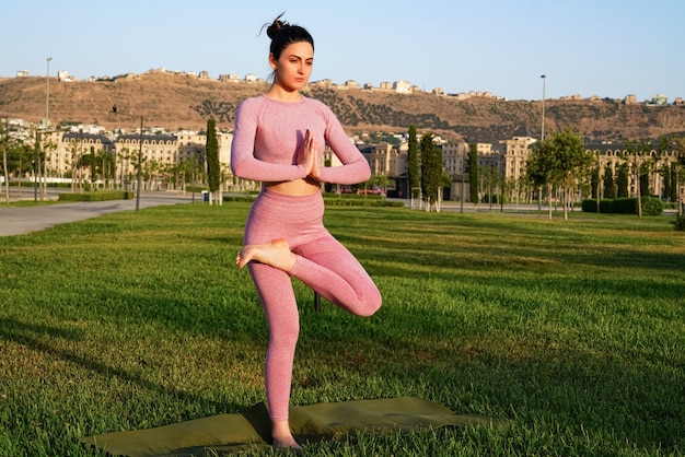 Yoga di pratica della donna allegra felice all'aperto