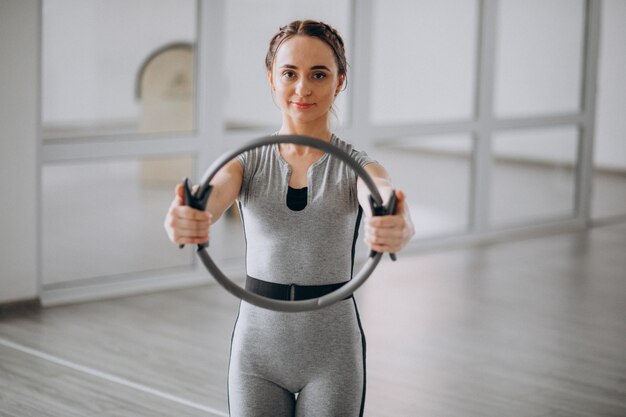 Yoga di pratica della donna nella palestra su una stuoia