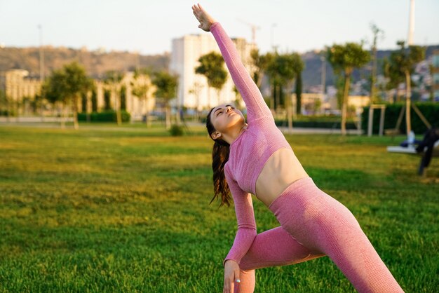 Yoga di pratica della giovane donna sportiva