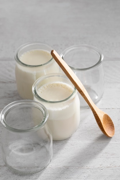 Yogurt delizioso ad alto angolo e cucchiaio di legno