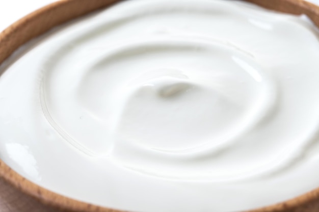 Yogurt greco in ciotola di legno isolato su sfondo bianco