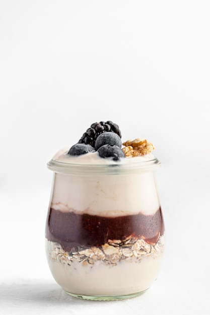 Yogurt vista frontale con marmellata, avena e frutti di bosco